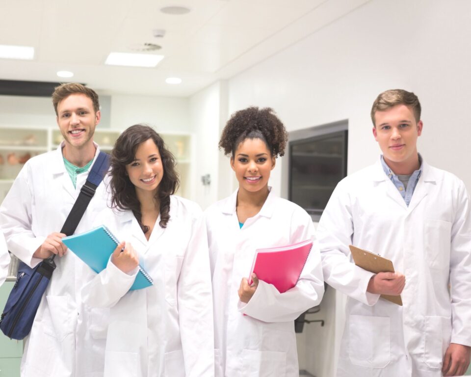 Young students in white robes in the hospital setting
