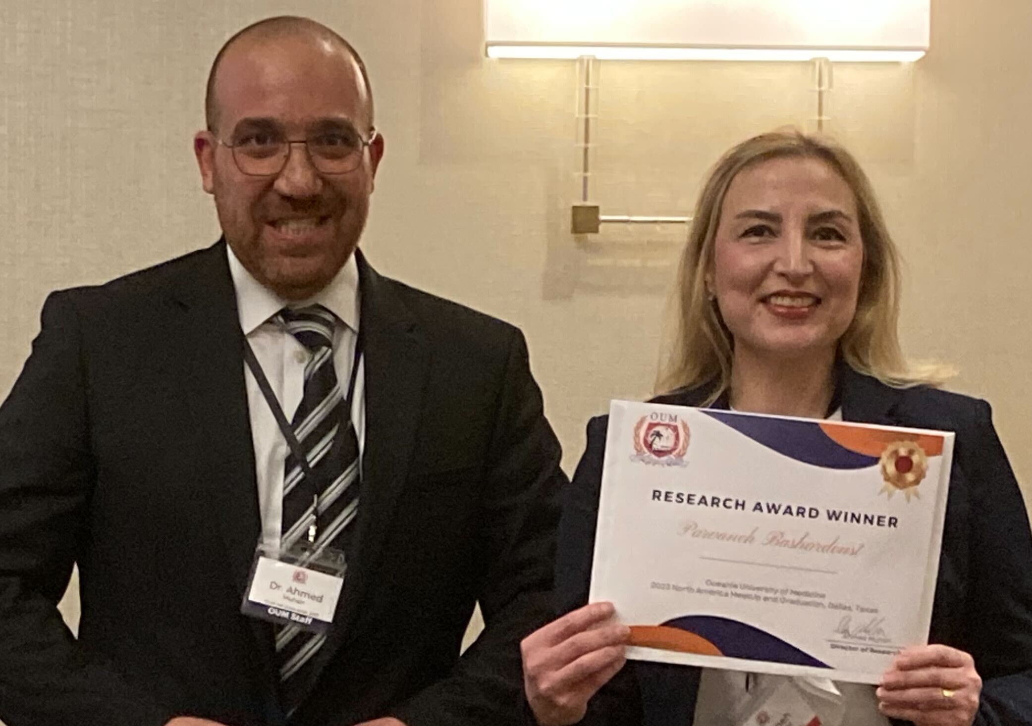smiling medical school faculty member with smiling student who won an award
