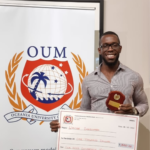 a person holding a large check and a medal